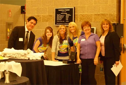 Group of people posing together at an indoor event