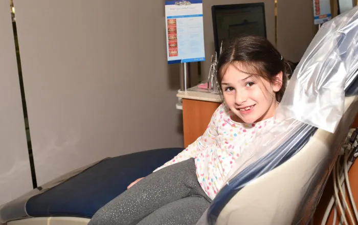 Young girl smiling in an orthodontic treatment chair