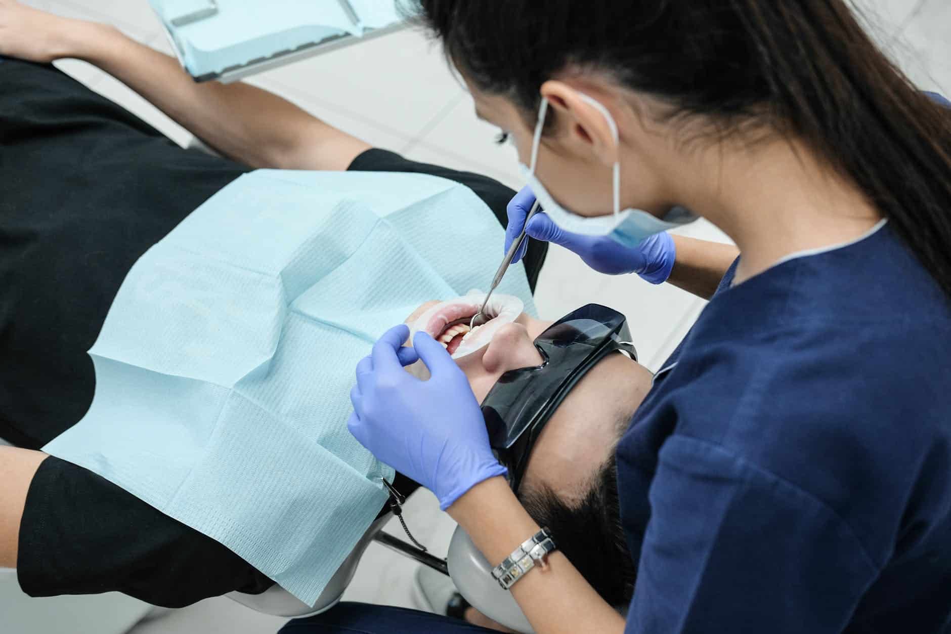 Dental professional treating someone reclined in a dental chair