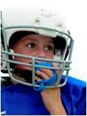 Young football player in a helmet wearing a mouth guard