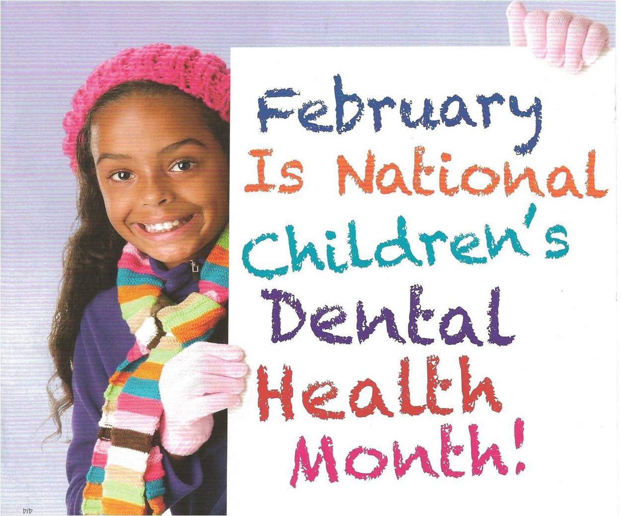 Smiling girl holding a sign that reads February Is National Children's Dental Health Month