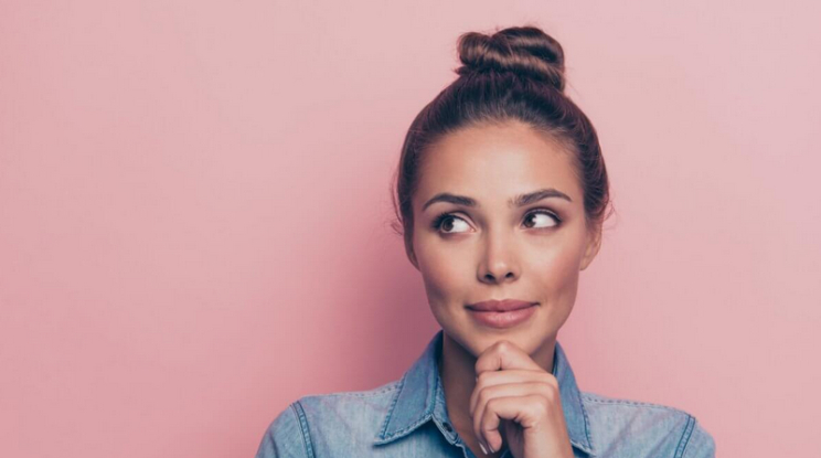 Thoughtful young woman against a pink background
